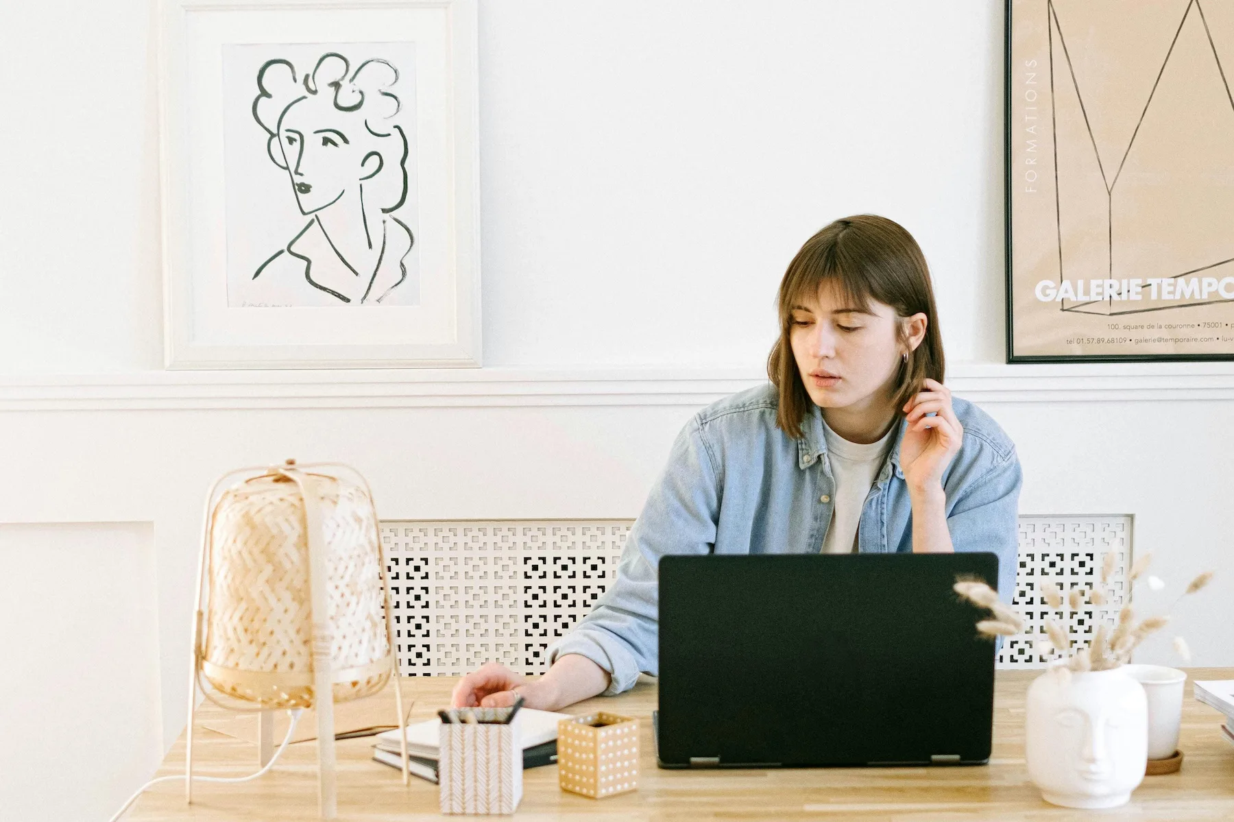Person working at a laptop in a calm workspace, representing focus-first coordination.